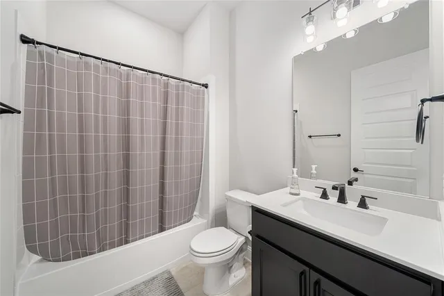 a bathroom with a sink a toilet and shower curtain