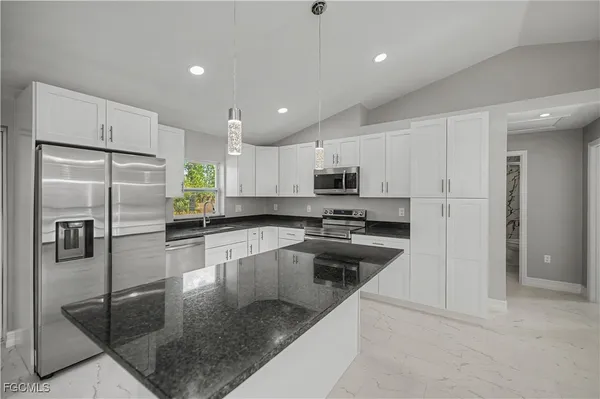 a kitchen with a sink a counter top space and cabinets