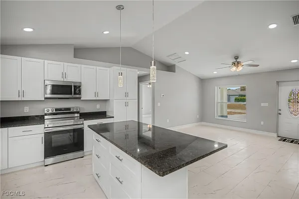 a kitchen with stainless steel appliances granite countertop a sink and stove top oven