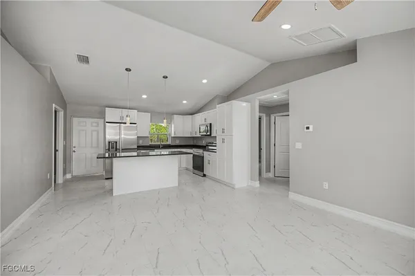 an empty room with windows and fan