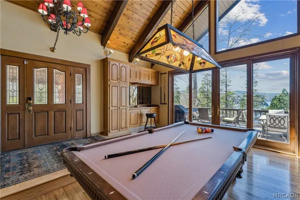 a living room with furniture large window and wooden floor