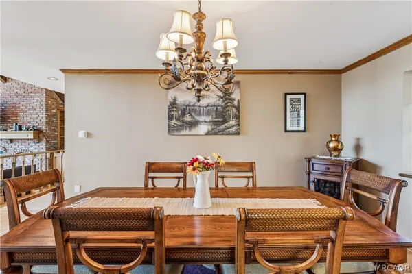 a dining room with furniture a chandelier and wooden floor