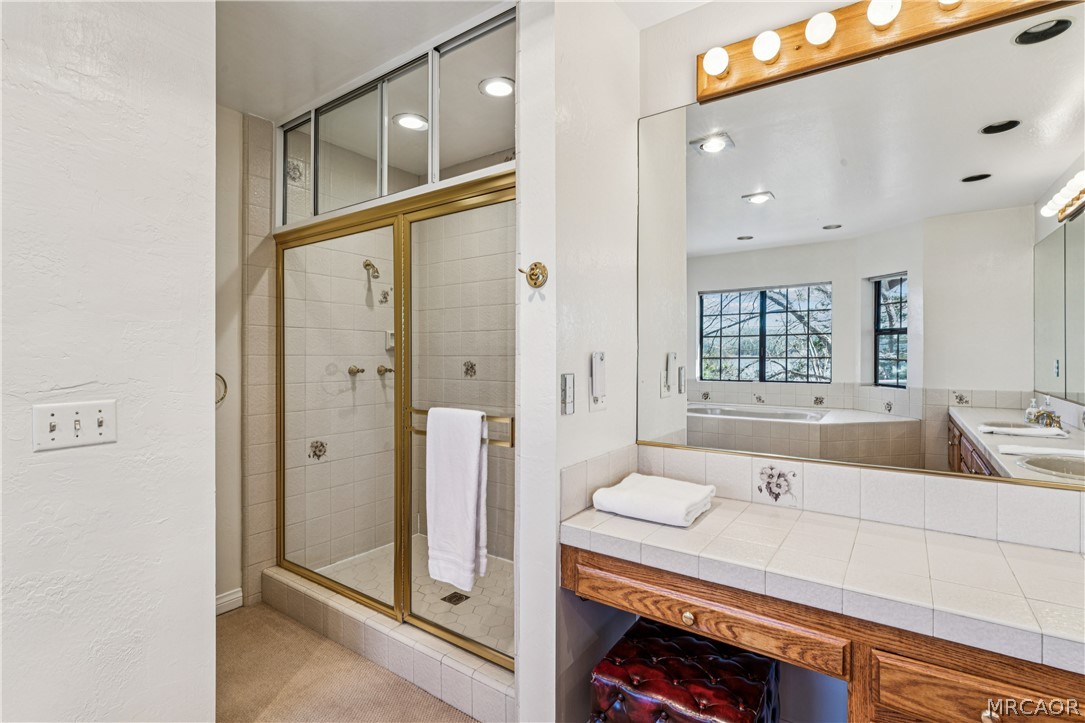 28994 North Shore Road Lake Arrowhead, CA 92352 - Photo 29 of 50 a bathroom with a granite countertop sink mirror and shower