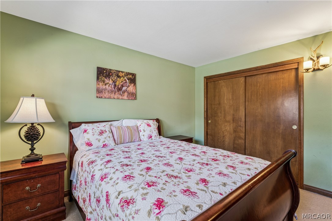 28994 North Shore Road Lake Arrowhead, CA 92352 - Photo 33 of 50 a bedroom with a bed and a lamp on dresser