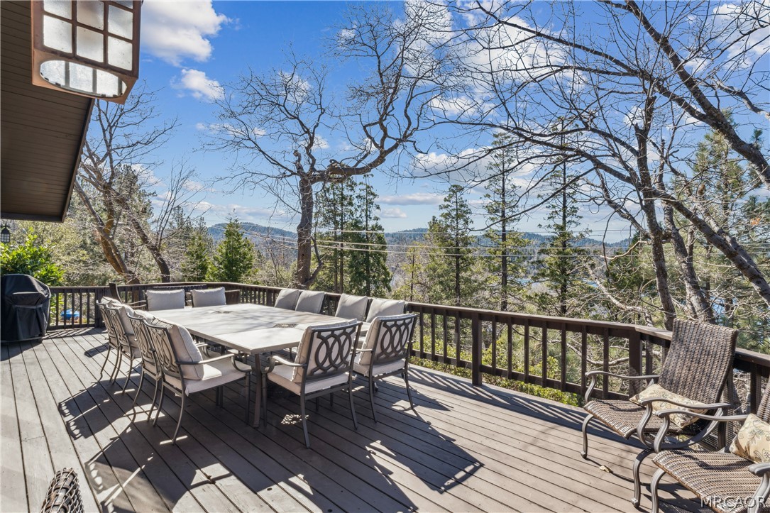 28994 North Shore Road Lake Arrowhead, CA 92352 - Photo 39 of 50 a view of a roof deck with table and chairs with wooden floor and fence