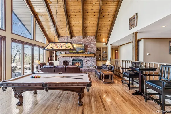a living room with furniture a fireplace and large windows