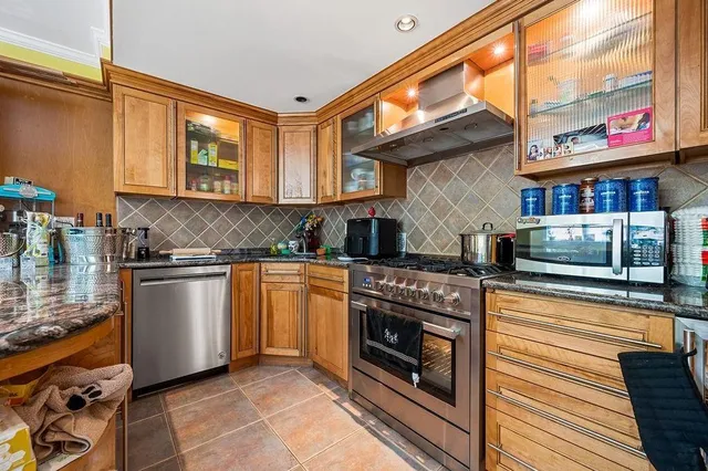 a kitchen with stainless steel appliances granite countertop a stove and a microwave