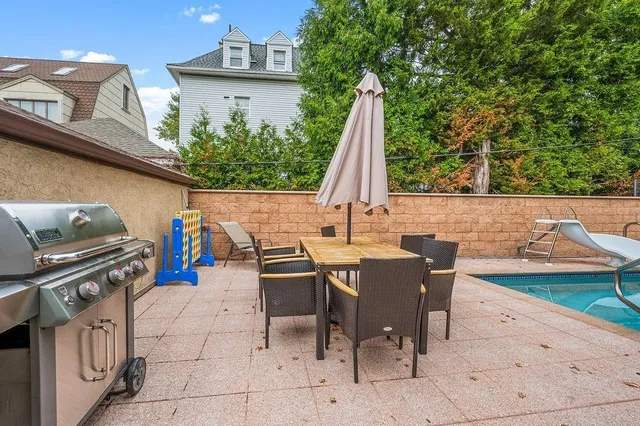 a view of outdoor kitchen with dining table and chairs