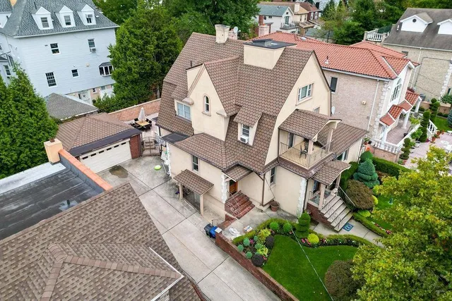 an aerial view of residential houses with outdoor space and trees