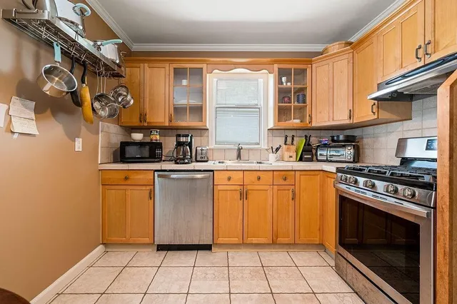 a kitchen with stainless steel appliances granite countertop a stove a sink and a microwave