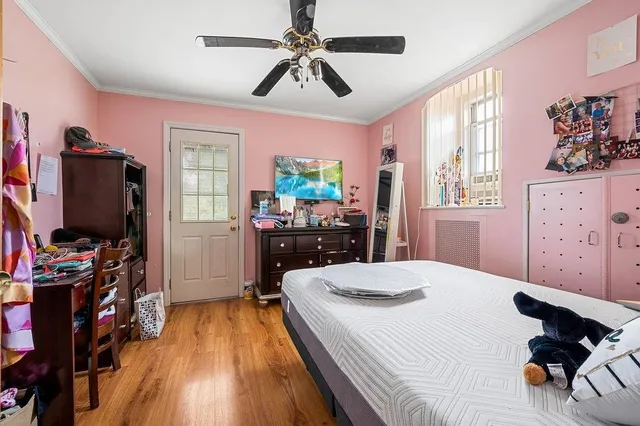 a bedroom with a bed and a flat tv screen on the dresser