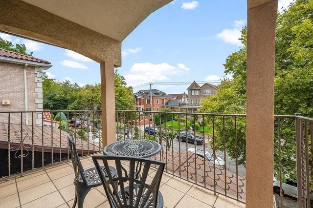 a view of a balcony with chairs and iron fence
