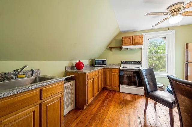 a kitchen with stainless steel appliances granite countertop a stove a sink and dishwasher with wooden floor