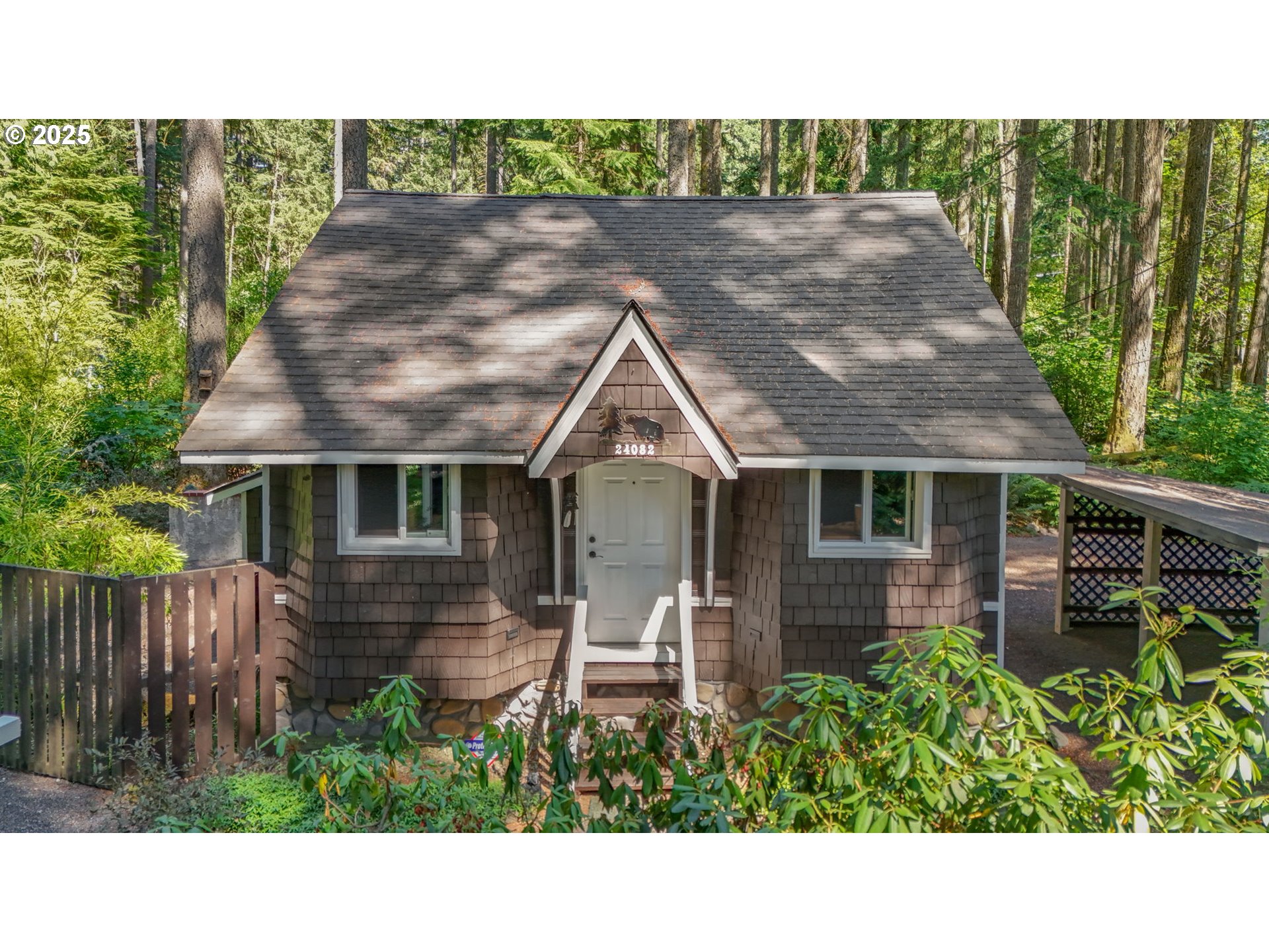 24082 East Decatur Road Welches, OR 97067 - Photo 1 of 44 a view of a house with brick walls plants and large tree