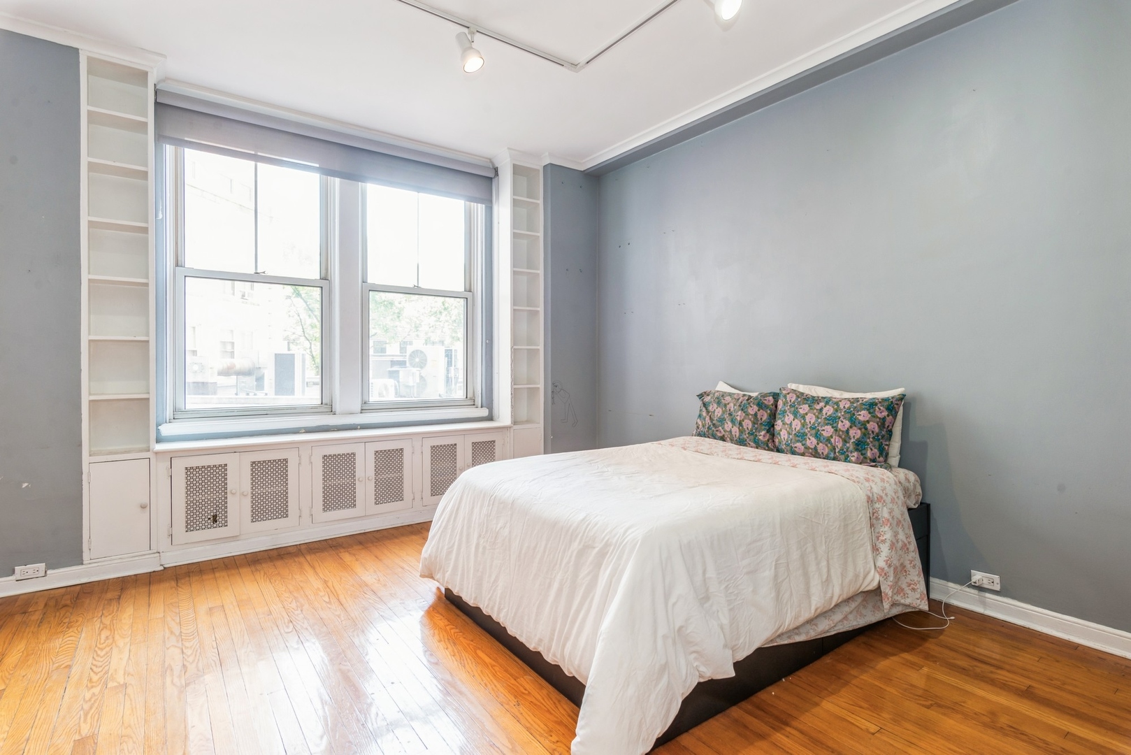 5555 North Sheridan Road, Unit 131 Chicago, IL 60640 - Photo 4 of 24 a large bed sitting in a bedroom next to a window