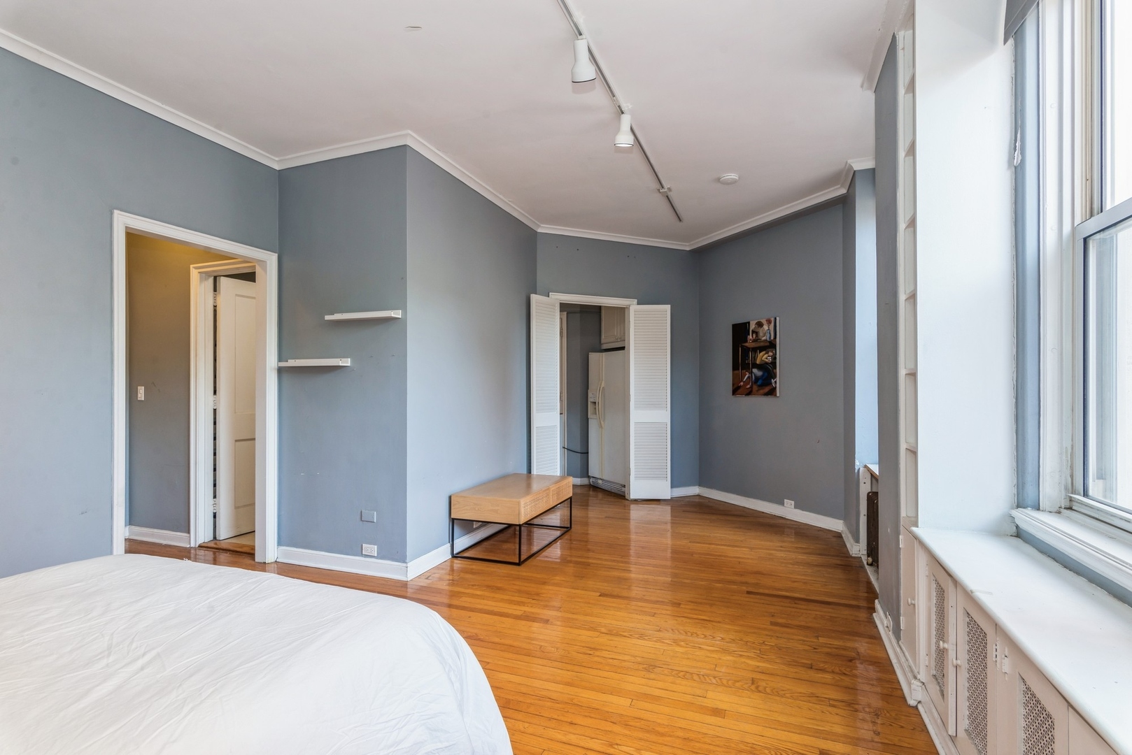 5555 North Sheridan Road, Unit 131 Chicago, IL 60640 - Photo 5 of 24 a bedroom with a bed and wooden floor