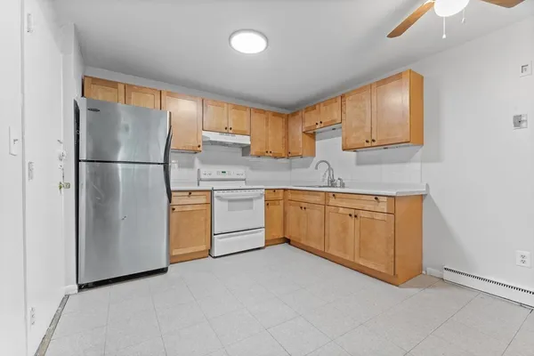 a kitchen with a refrigerator sink and cabinets