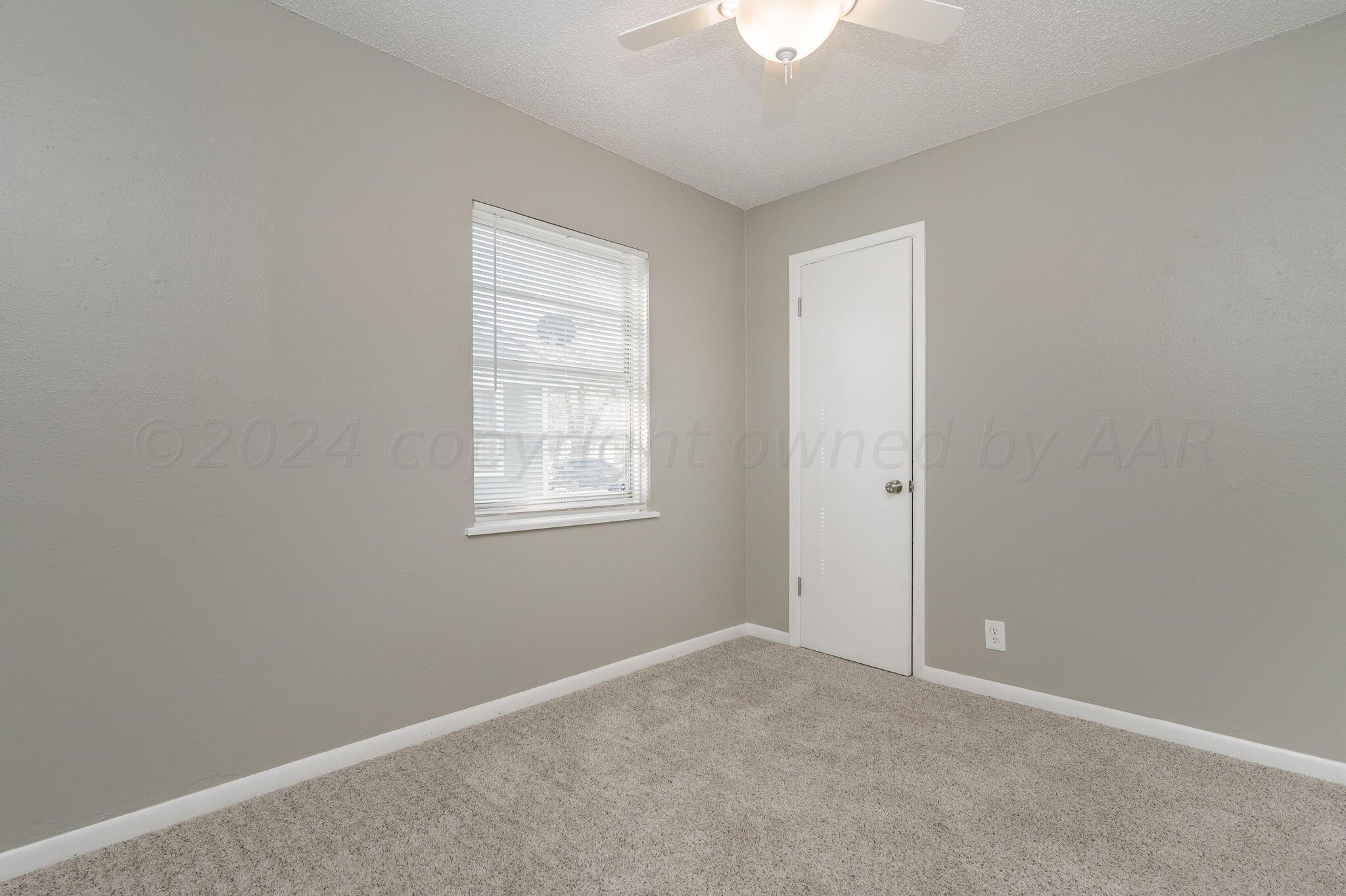 4207 South Ong Street Amarillo, TX 79110 - Photo 11 of 16 an empty room with a chandelier fan