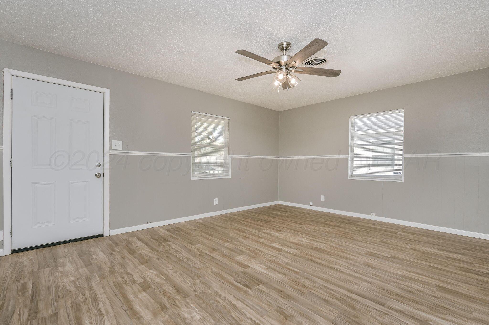 4207 South Ong Street Amarillo, TX 79110 - Photo 4 of 16 a view of an empty room with wooden floor and a window