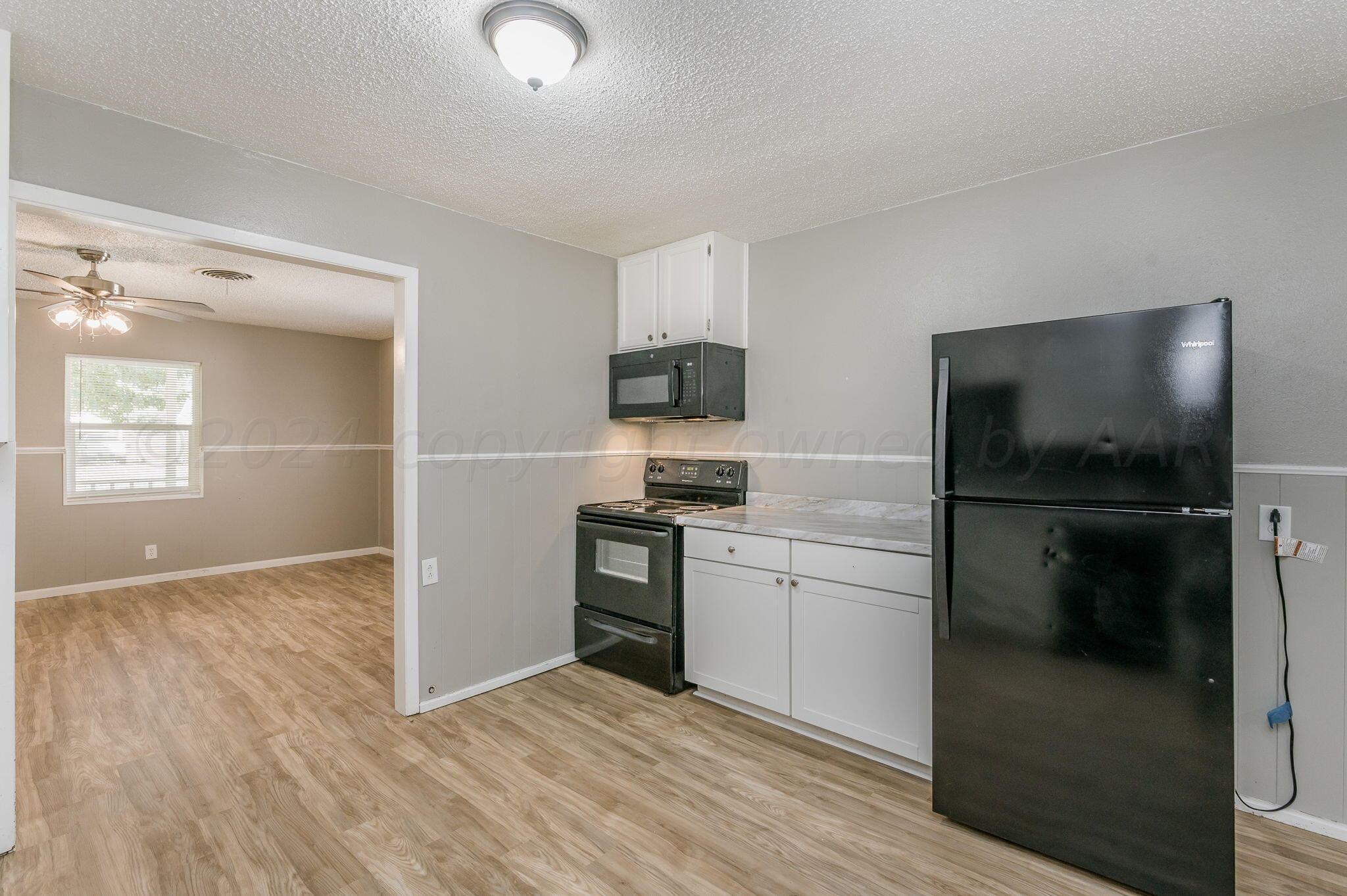 4207 South Ong Street Amarillo, TX 79110 - Photo 6 of 16 a kitchen with a refrigerator and a stove top oven