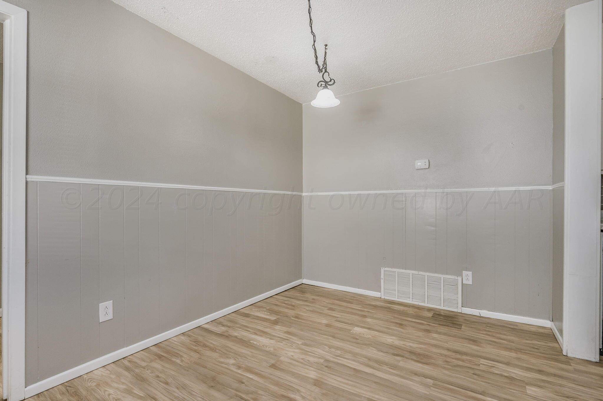4207 South Ong Street Amarillo, TX 79110 - Photo 8 of 16 a view of a room with wooden floor and white walls