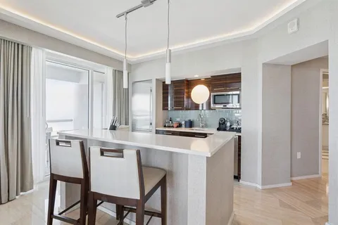 a kitchen with stainless steel appliances a sink a stove and a refrigerator with wooden floor