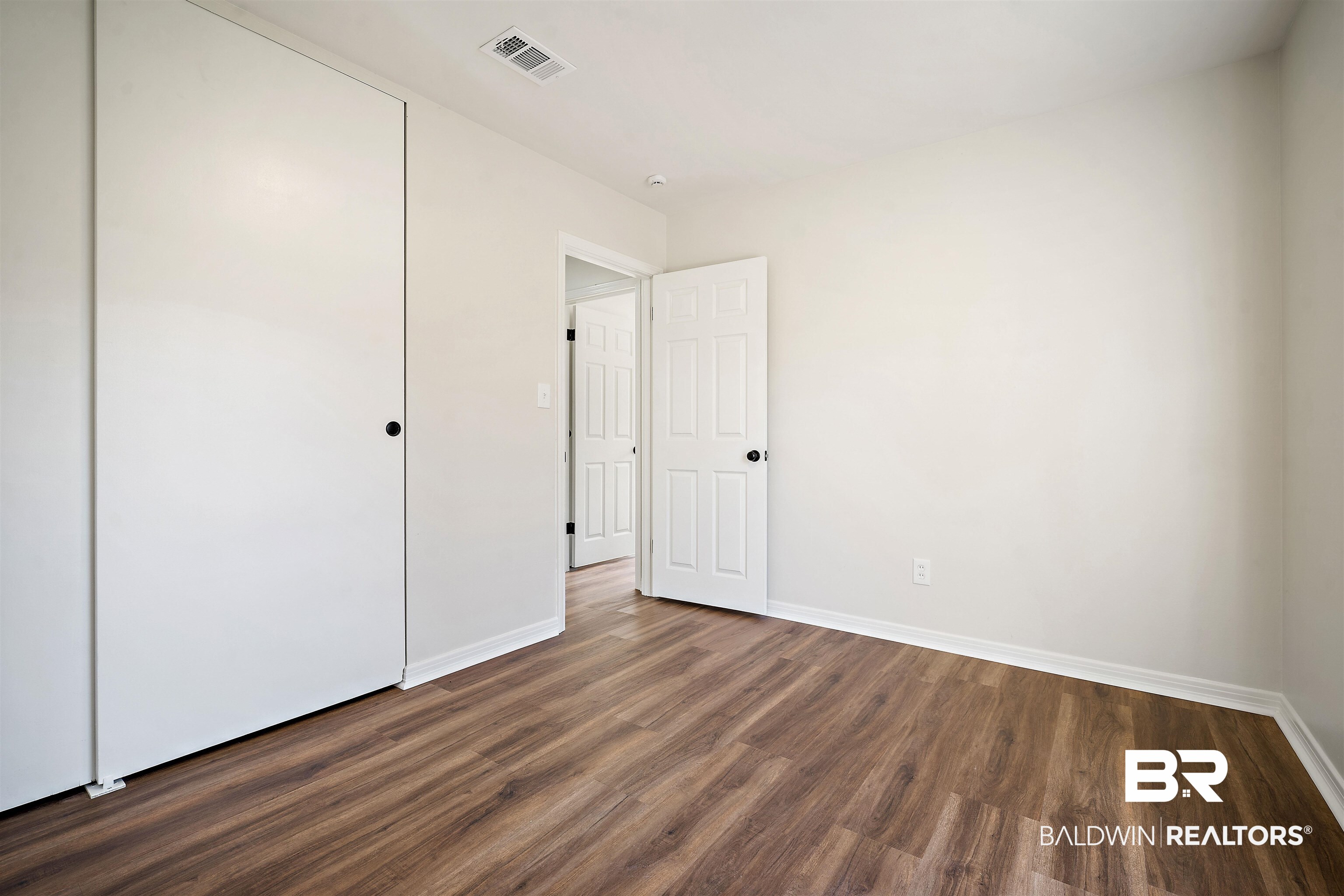 860 Montfort Road South Mobile, AL 36608 - Photo 22 of 27 Unfurnished bedroom featuring dark wood-style flooring and a closet