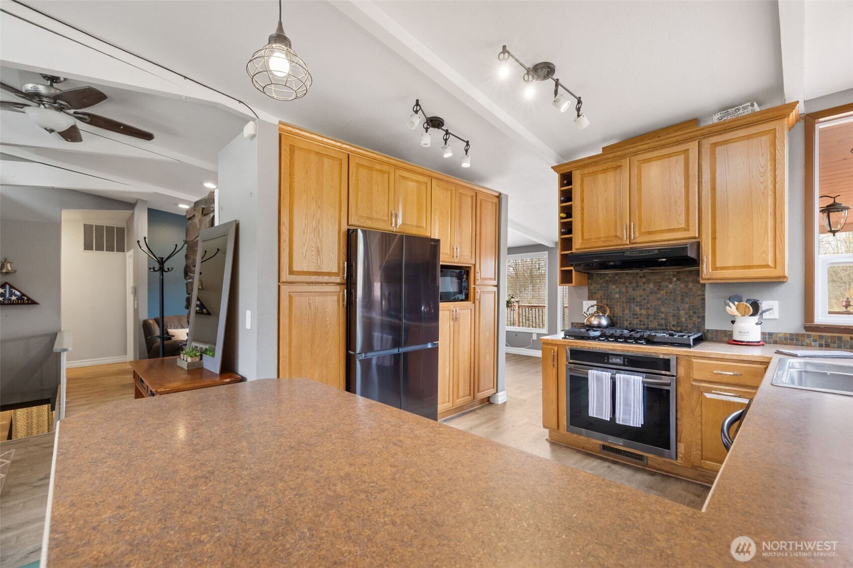 11782 Schold Road Northwest Silverdale, WA 98383 - Photo 8 of 40 a kitchen with stainless steel appliances granite countertop a refrigerator a stove top oven a sink dishwasher and wooden cabinets