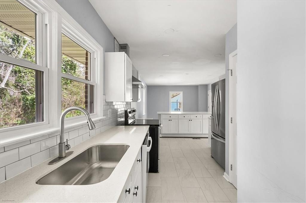 2763 Baker Ridge Drive Northwest Atlanta, GA 30318 - Photo 11 of 32 a kitchen with a sink cabinets a window and stainless steel appliances