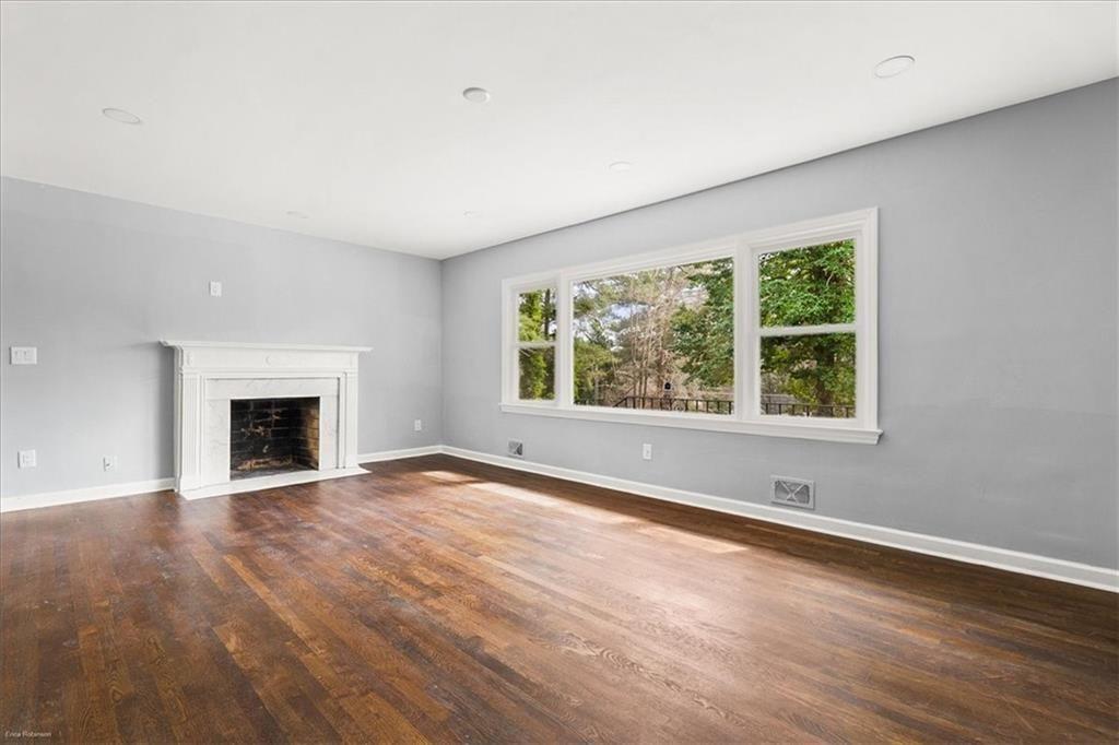 2763 Baker Ridge Drive Northwest Atlanta, GA 30318 - Photo 7 of 32 an empty room with wooden floor and fireplace