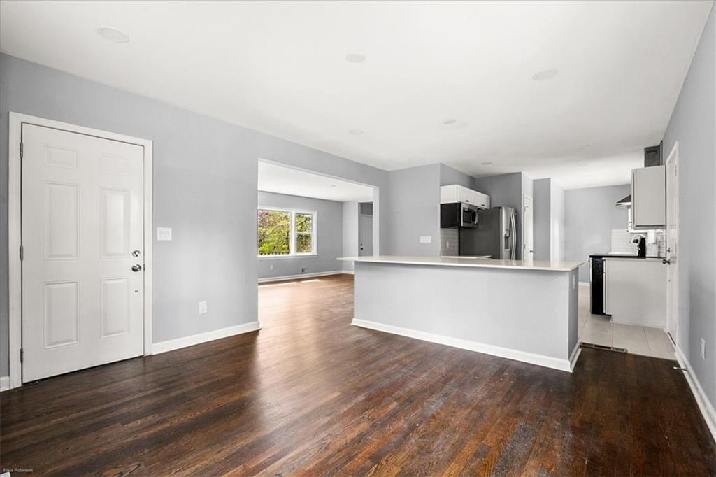 2763 Baker Ridge Drive Northwest Atlanta, GA 30318 - Photo 9 of 32 a view of a kitchen and an empty room with wooden floor and a kitchen