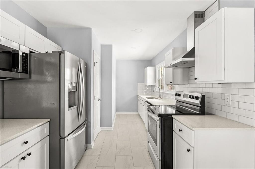 2763 Baker Ridge Drive Northwest Atlanta, GA 30318 - Photo 10 of 32 a kitchen with stainless steel appliances a refrigerator sink and microwave