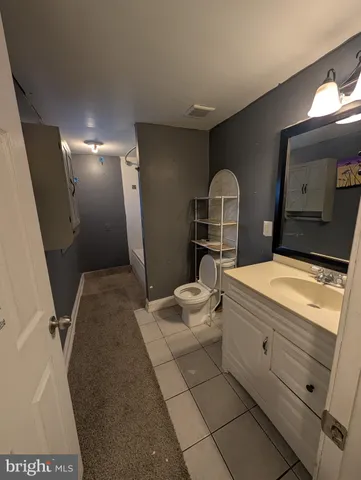 a bathroom with a granite countertop sink mirror vanity and toilet