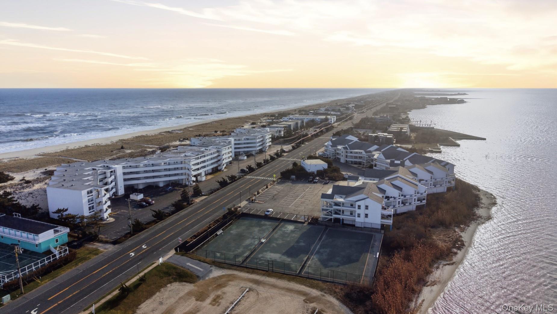 253 Dune Road, Unit 49 Westhampton Beach, NY 11978 - Photo 23 of 28 Aerial View of The Yardarm's Ocean and Bay Front community, Along with Their 3 Tennis Courts.