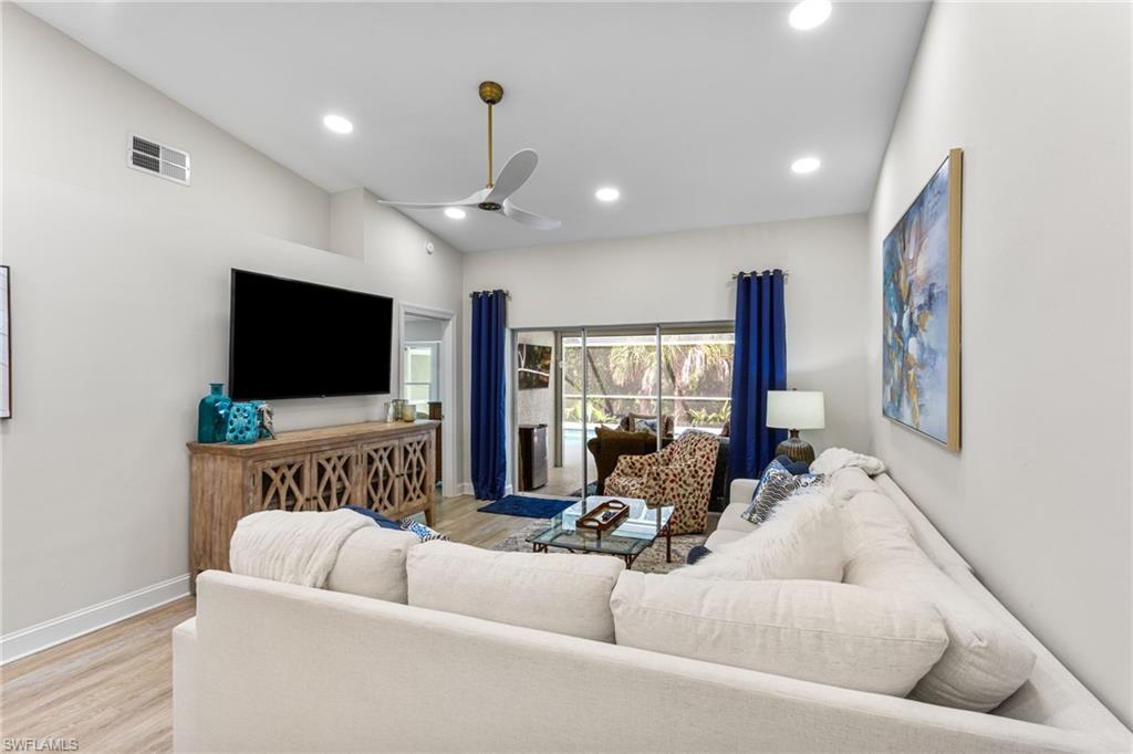 754 Wiggins Bay Drive Naples, FL 34110 - Photo 12 of 34 a living room with furniture and a flat screen tv