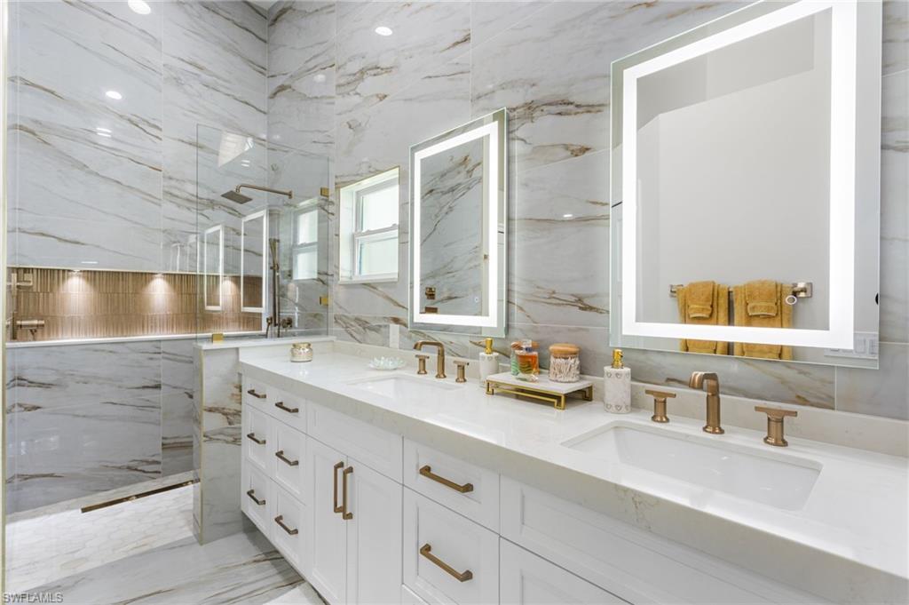 754 Wiggins Bay Drive Naples, FL 34110 - Photo 17 of 34 a bathroom with a double vanity sink mirror and double