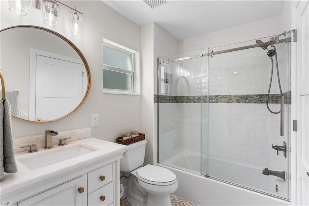 754 Wiggins Bay Drive Naples, FL 34110 - Photo 18 of 34 a bathroom with a granite countertop sink toilet and shower