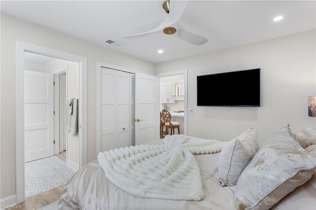 754 Wiggins Bay Drive Naples, FL 34110 - Photo 19 of 34 a living room with a flat screen tv and a white bed