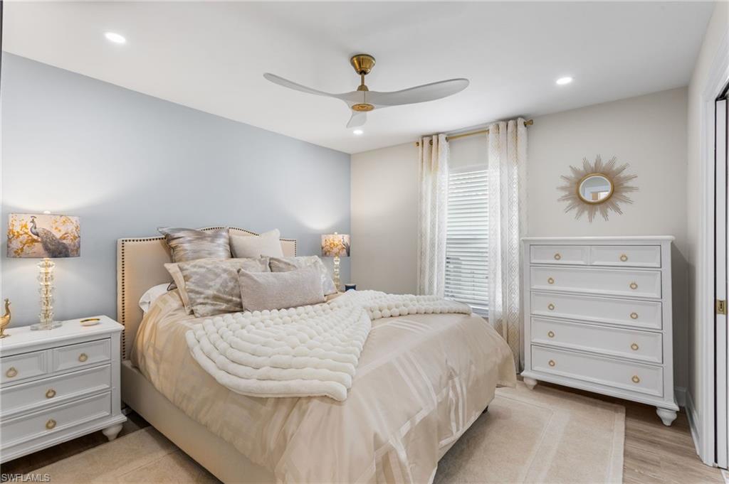 754 Wiggins Bay Drive Naples, FL 34110 - Photo 20 of 34 a bedroom with a bed and a chandelier