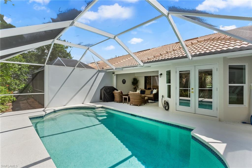 754 Wiggins Bay Drive Naples, FL 34110 - Photo 25 of 34 a view of a patio with table and chairs under an umbrella