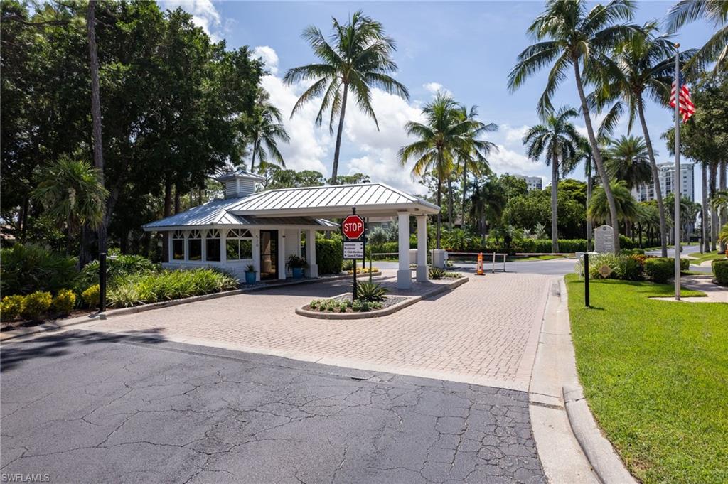754 Wiggins Bay Drive Naples, FL 34110 - Photo 31 of 34 a view of a swimming pool with lawn chairs under an umbrella