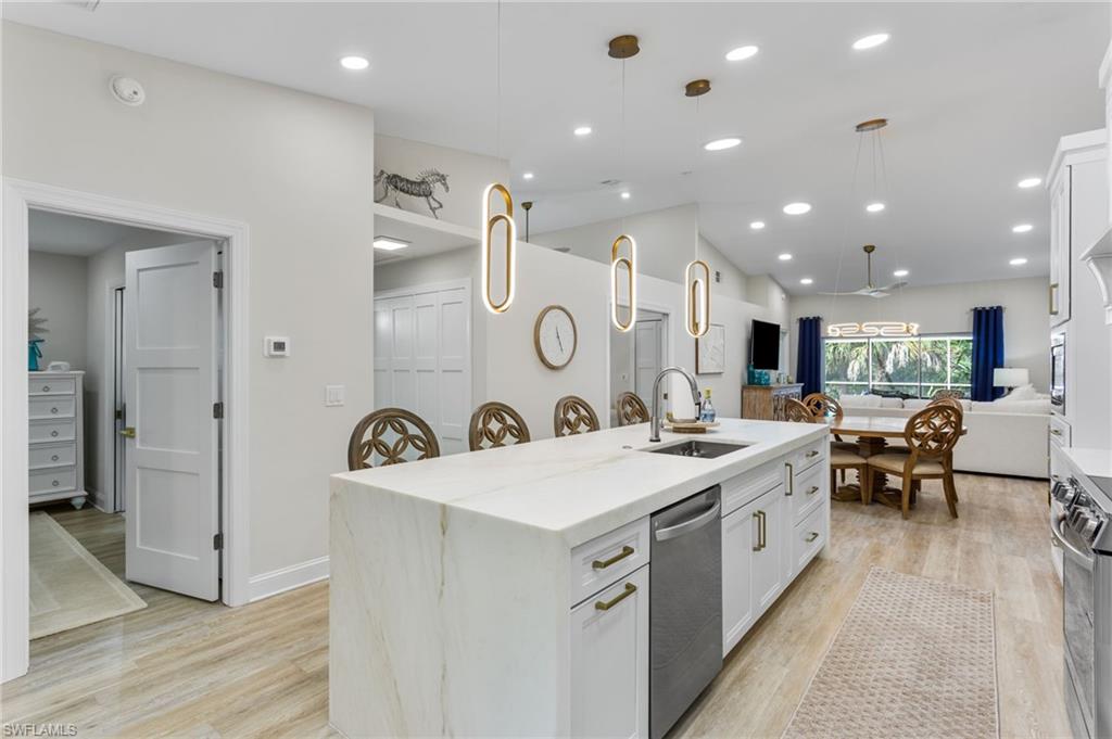 754 Wiggins Bay Drive Naples, FL 34110 - Photo 5 of 34 a large kitchen with a large counter top a sink a stove and a refrigerator
