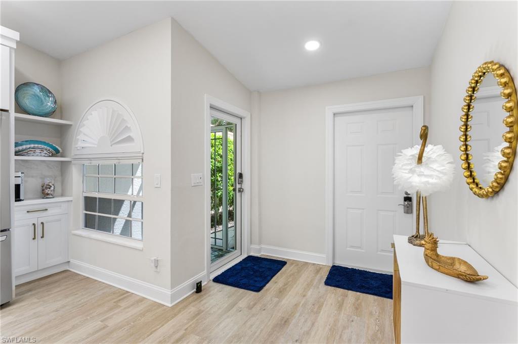 754 Wiggins Bay Drive Naples, FL 34110 - Photo 6 of 34 a view of a livingroom with wooden floor and a ceiling fan