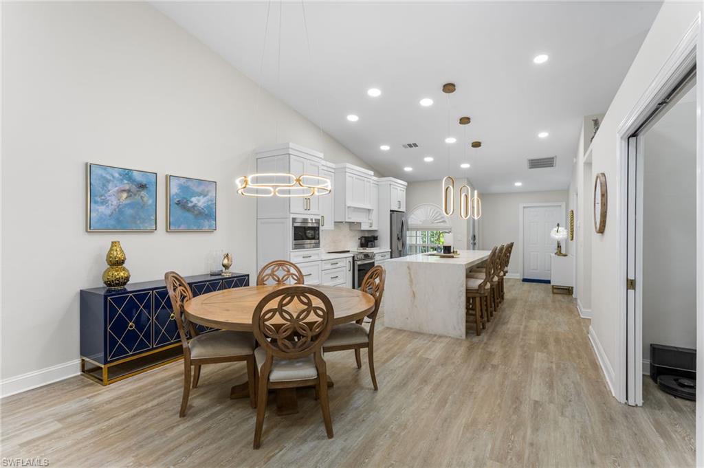754 Wiggins Bay Drive Naples, FL 34110 - Photo 7 of 34 a dining room with kitchen island stainless steel appliances furniture a dining table and chairs