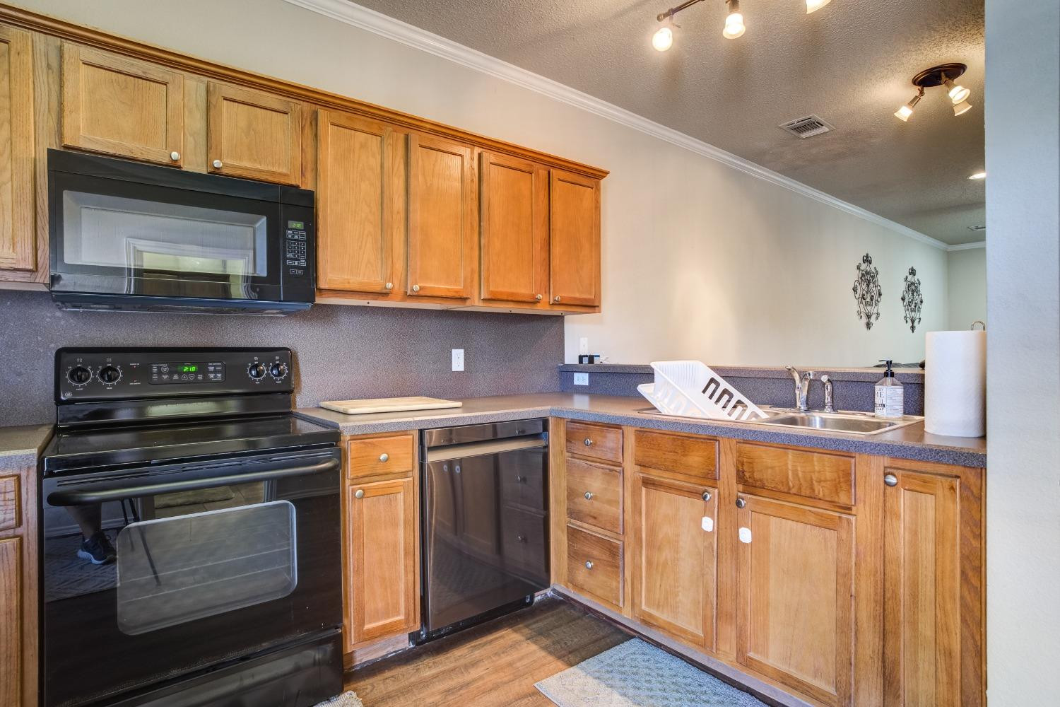 2101 Main Street, Unit 2 Lubbock, TX 79401 - Photo 13 of 31 a kitchen with stainless steel appliances granite countertop wooden cabinets stove top oven and sink