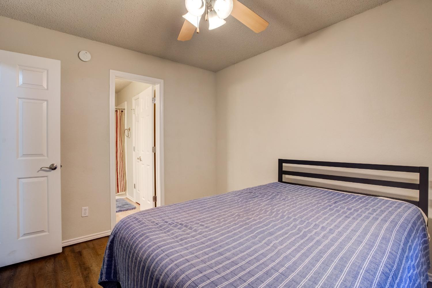 2101 Main Street, Unit 2 Lubbock, TX 79401 - Photo 17 of 31 a bedroom with a bed and wooden floor