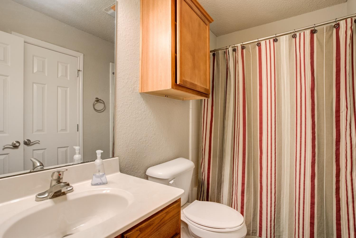 2101 Main Street, Unit 2 Lubbock, TX 79401 - Photo 19 of 31 a bathroom with a sink a toilet and shower curtain