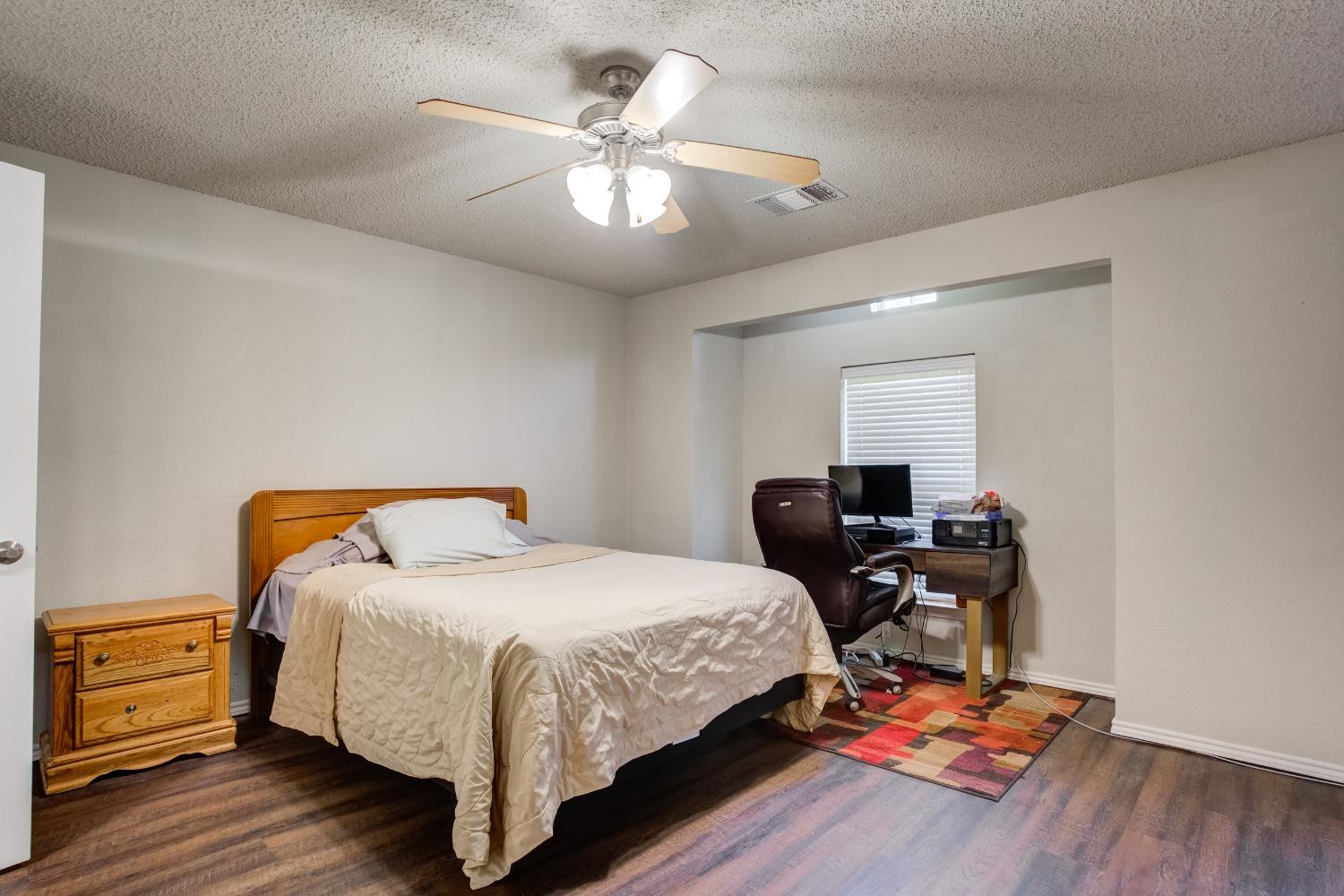 2101 Main Street, Unit 2 Lubbock, TX 79401 - Photo 21 of 31 a bedroom with a bed and wooden floor
