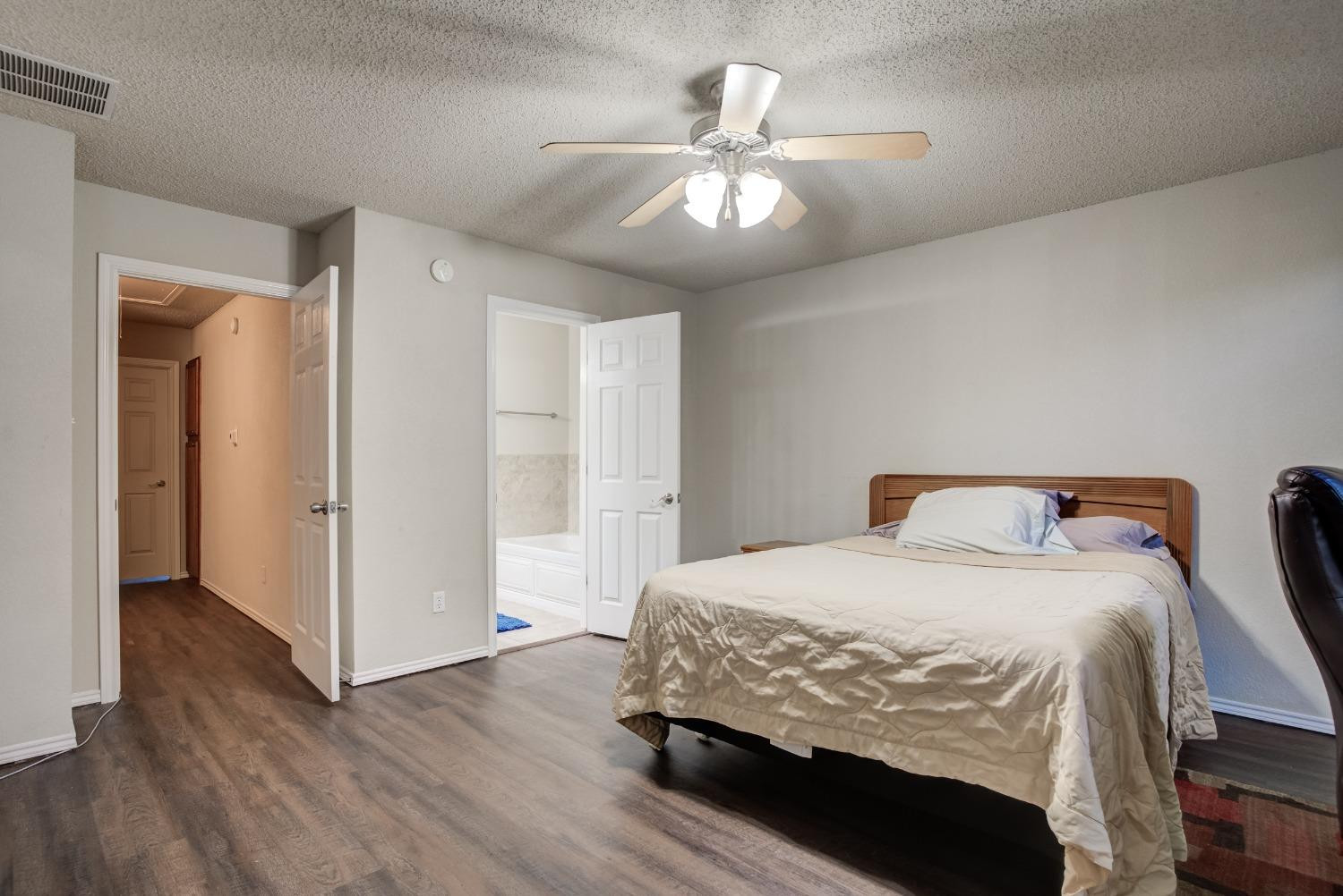 2101 Main Street, Unit 2 Lubbock, TX 79401 - Photo 22 of 31 a bedroom with a bed and a chandelier