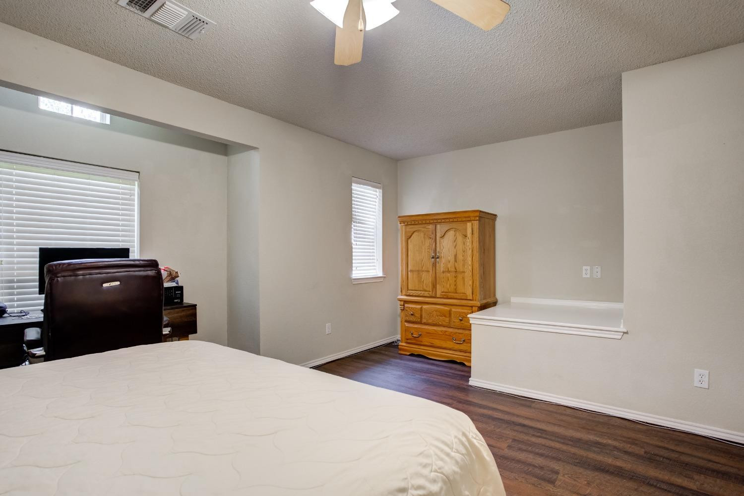 2101 Main Street, Unit 2 Lubbock, TX 79401 - Photo 23 of 31 a bedroom with a bed and wooden floor